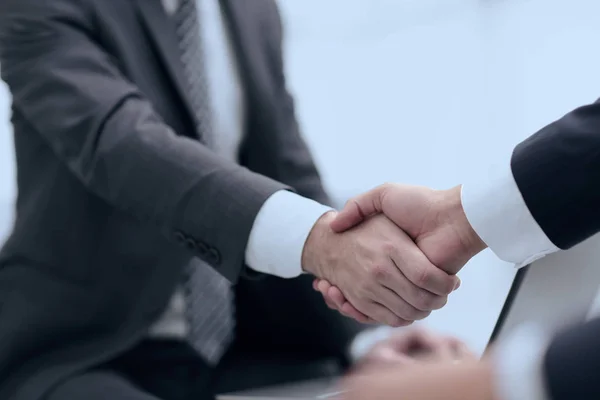 Крупный план деловых людей, пожимающих руки из-за сделки — стоковое фото
