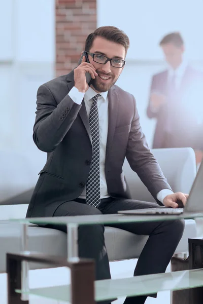 Изображение молодого бизнесмена, разговаривающего по мобильному телефону с клиентами — стоковое фото