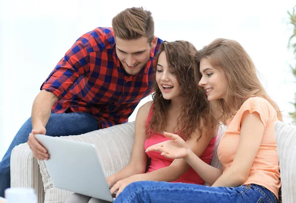 kanepede oturan bir dizüstü ekran bakarak öğrenci grubu