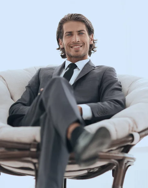 Egy nagy kényelmes karosszékben ül, jóképű üzletember. — Stock Fotó