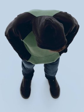 Yukarıdan görüntüleyin. Hipster aşağı bakıyor bir kukuleta ile ceket