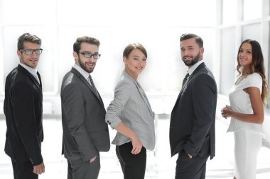 Arka manzara. İş ekibi gülümsüyor ve kameraya bakıyor.