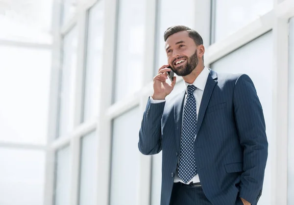 Hombre de negocios sonriente hablando en un teléfono móvil — Foto de Stock