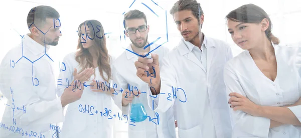 General-view seen trough a transparent board in a chemistry lab of people analyzing information — Stock Photo, Image