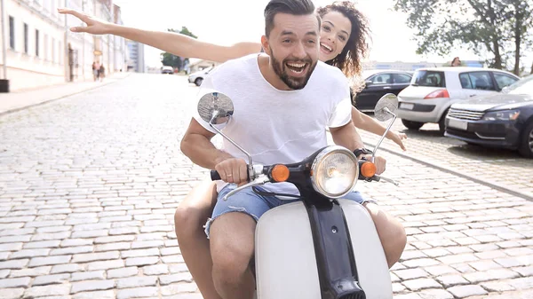 Vrolijke jonge paar rijden een scooter en plezier — Stockfoto