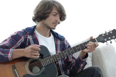 Yakışıklı adam evde kanepede gitar çalmaya