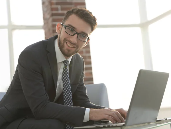 Бизнесмен в очках сидит за столом в офисе — стоковое фото