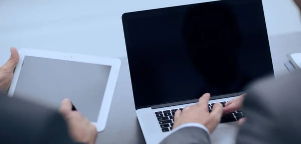 Primer plano. colegas de negocios que trabajan con Tablet PC y portátil . —  Fotos de Stock