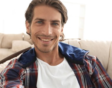 bir sandalyede oturuyor ve elini tutarak kendine güvenen adam.