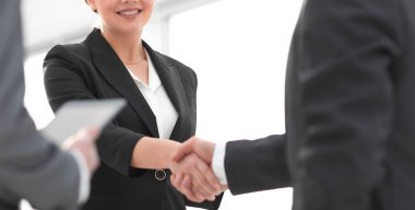 İş kadını toplantı sırasında bir işadamıyla tokalaşıyor.