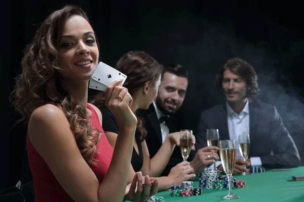 Young brunette woman playing poker on black background — Stock Photo, Image