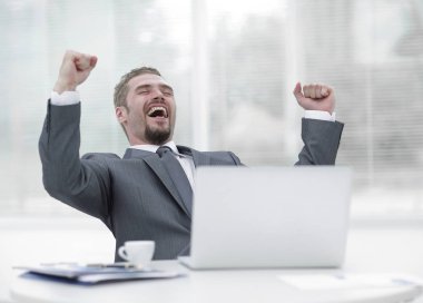 açık bir dizüstü bilgisayar önünde oturup closeup.happy iş adamı.