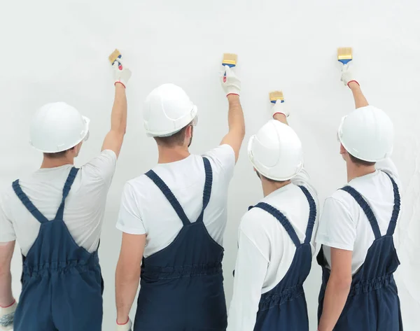 Rear view.construction workers paint the wall. — Stock Photo, Image