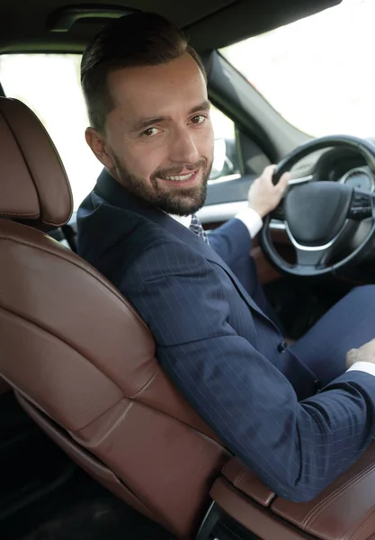 Businessman sitting at the wheel of a prestigious car — Stock Photo, Image