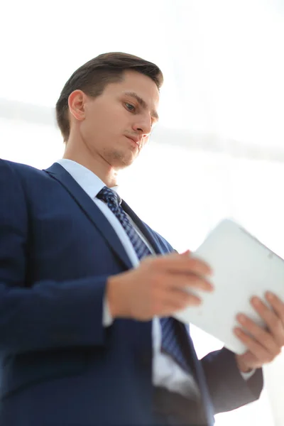 Уверенный молодой бизнесмен в костюме с помощью планшета — стоковое фото