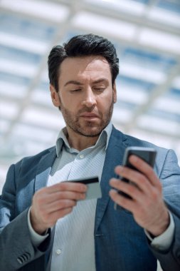 Kapat. İş adamı akıllı telefondan numarayı arıyor.