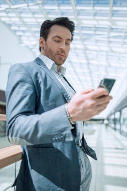 işadamı Havaalanı binasının önünde duran smartphone ile