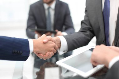 Ofiste iş arkadaşlarıyla tokalaşan adamlar..