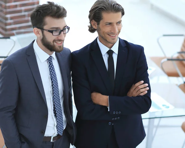 Впевнені бізнесмени, що стоять разом в офісі — стокове фото