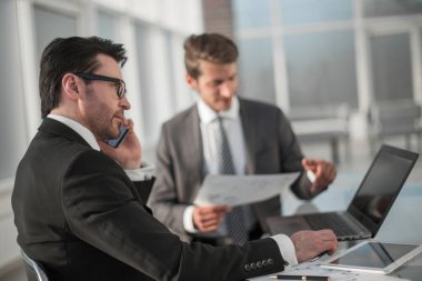 çalışanların yeni veriyi denetlemek için bir dizüstü bilgisayar kullanmak.