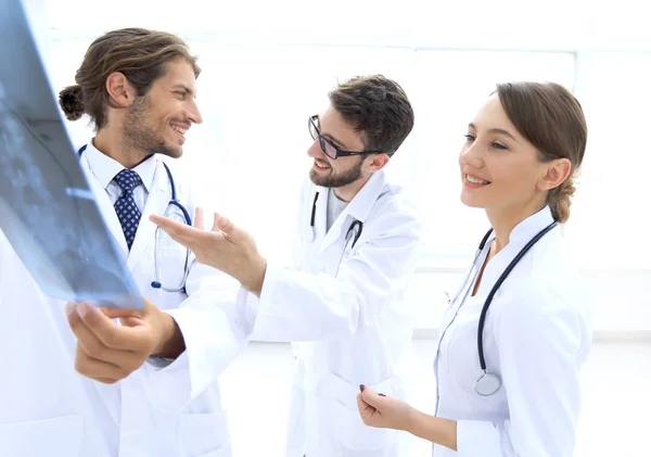 Tres doctores confiados examinan una radiografía — Foto de Stock