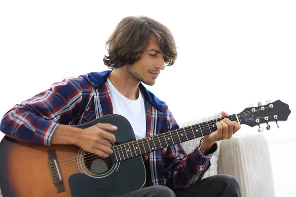 Bonito homem tocando na guitarra no sofá em casa — Fotografia de Stock