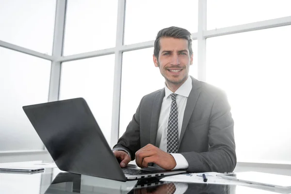 Sorridente empresário sentado em sua mesa — Fotografia de Stock