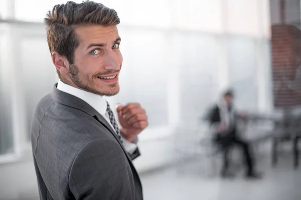 Up.smiling zakenman staande voor het office-venster sluiten — Stockfoto