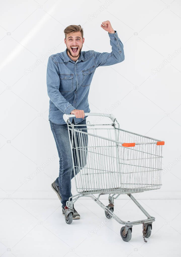 Full length portrait of a happy man running with a shopping trolley