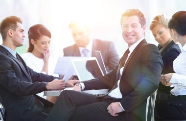 iş adamı ve iş ekibi ile finansal belgeler bankanın lobisinde bir masada oturan.