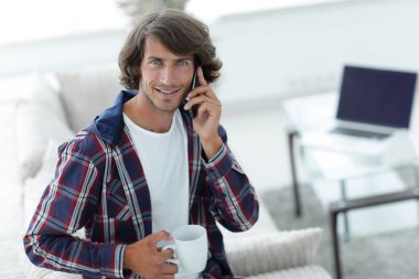 güzel bir fincan adamla bir dizüstü bilgisayar önünde oturur.