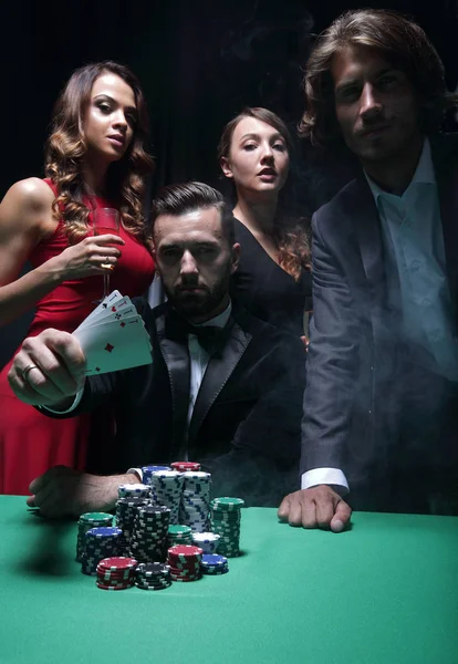 Homens e mulheres concentrados jogando poker no cassino — Fotografia de Stock