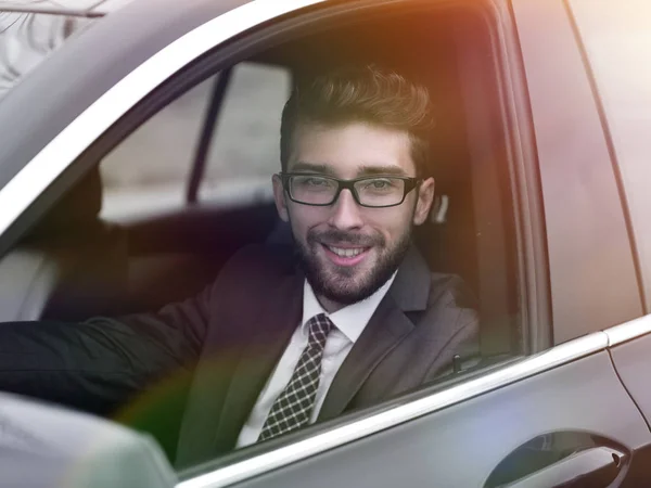 Uomo d'affari in giacca e cravatta guida la sua auto di lusso . — Foto Stock