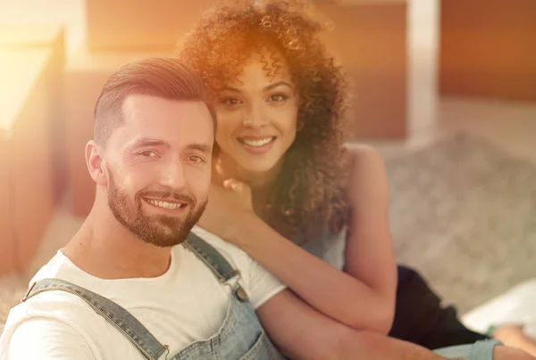 Young couple sitting on the floor in a new apartment — Stock Photo, Image