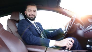 Yan emin işadamı görünümünden bir araba direksiyon başında oturur