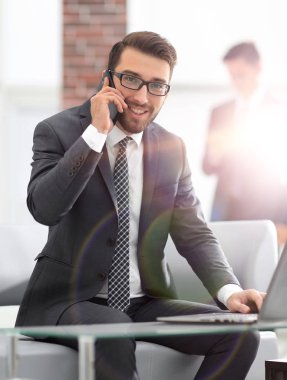genç işadamı cep telefonu üzerinde müşterilerle konuşurken görüntüsünü