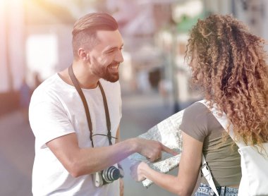 Genç çift mutlu görünürken bir rehbere bakıyor.