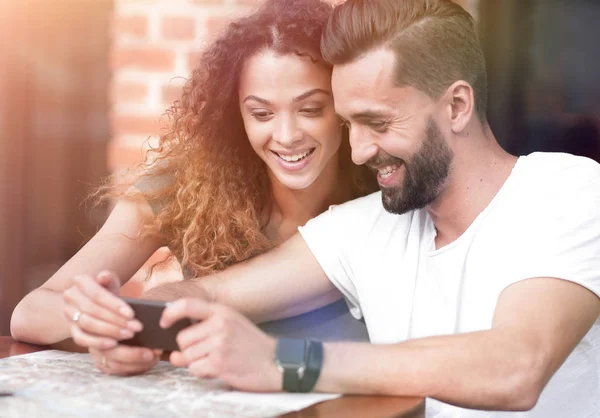 Šťastný, milující pár pomocí smartphone, posezení na terase — Stock fotografie