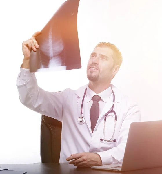 Médico examina um raio-x, sentado atrás de uma mesa — Fotografia de Stock