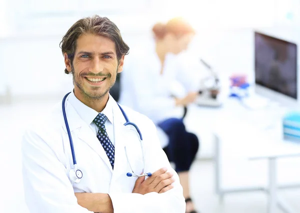 Knappe mannelijke arts glimlachend met armen gekruist op borst portret — Stockfoto