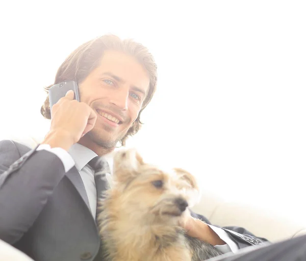 Primer plano de un hombre de negocios hablando por teléfono y sosteniendo a su mascota . — Foto de Stock