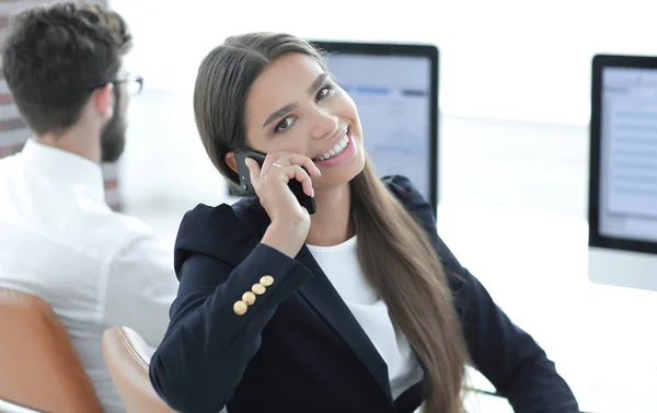 Vrouwelijke werknemer praten op een mobiele telefoon met een klant — Stockfoto