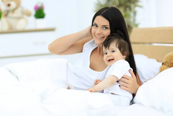 Portrait of a beautiful mother with her baby in the bedroom — Stock Photo, Image