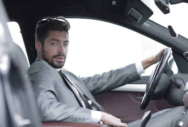 Hombre de negocios guapo en el asiento de los conductores en su coche — Foto de Stock