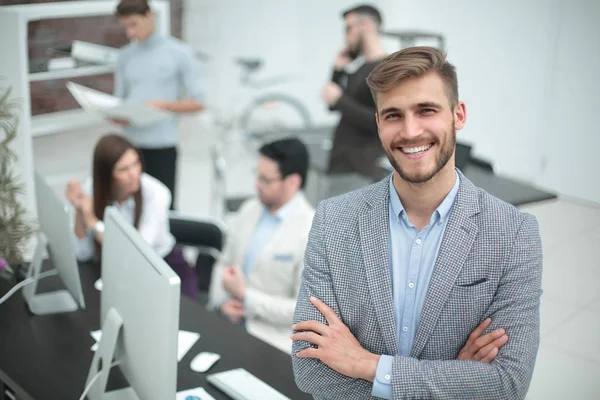 Joven empresario sonriente en el fondo de la oficina — Foto de Stock