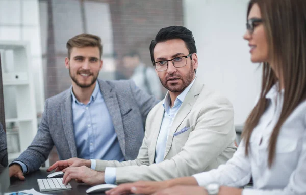 Stäng up.businessman och anställda som sitter vid skrivbordet — Stockfoto