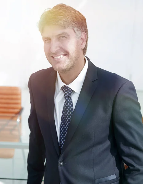 Homme d'affaires prospère debout près du bureau . — Photo