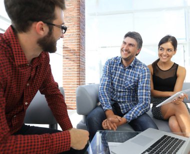 Yöneticiler Office dizüstü bilgisayar ile oturup gülümseyen portresi