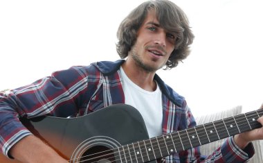 adam bir şarkı söyler ve kanepede oturan gitar çalar.