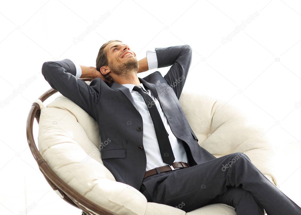 young businessman meditating in big comfortable armchair